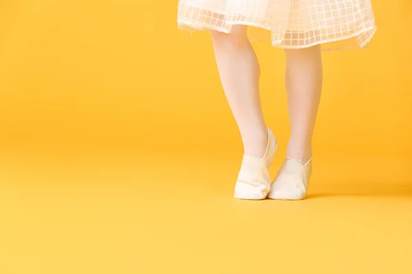 Las piernas de la pequeña bailarina sobre el fondo de color — Foto de Stock