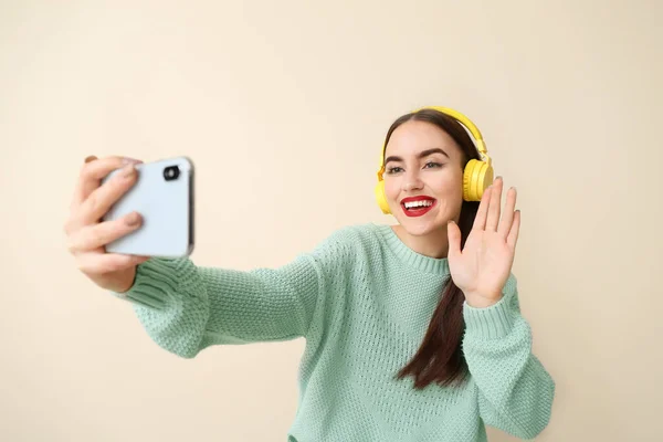 Beautiful young woman taking selfie on color background — Stock Photo, Image