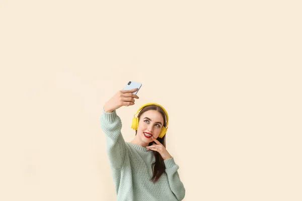 Beautiful young woman taking selfie on color background — Stock Photo, Image