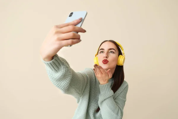 Beautiful young woman taking selfie on color background — Stock Photo, Image