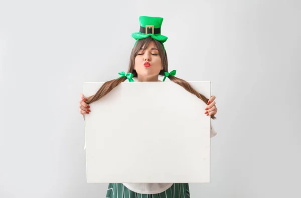 Funny young woman with blank poster on light background. St. Patrick's Day celebration — 스톡 사진