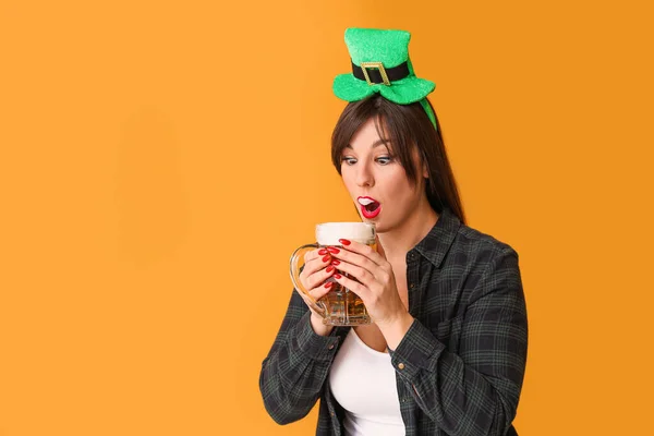 Grappige jonge vrouw met bier op kleur achtergrond. St. Patrick 's Day viering — Stockfoto