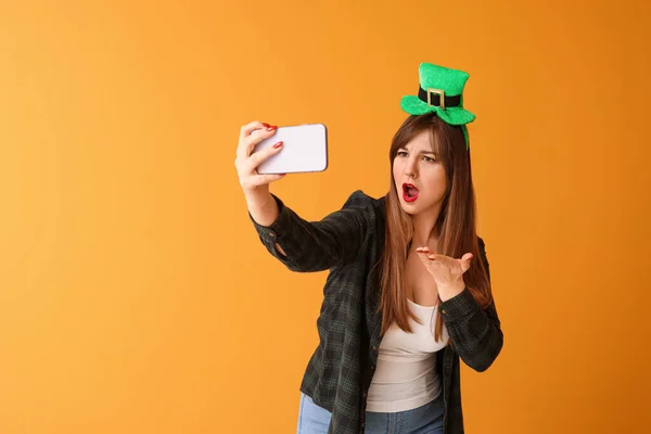 Zabawna młoda kobieta robiąca selfie na tle koloru. Święto św. Patryka — Zdjęcie stockowe