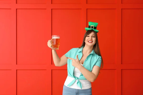 Funny young woman with beer on color background. St. Patrick\'s Day celebration