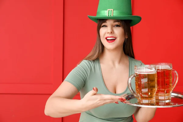Zabawna młoda kobieta z piwem na tle koloru. Święto św. Patryka — Zdjęcie stockowe