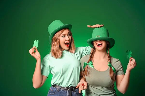 Grappige jonge vrouwen op kleur achtergrond. St. Patrick 's Day viering — Stockfoto