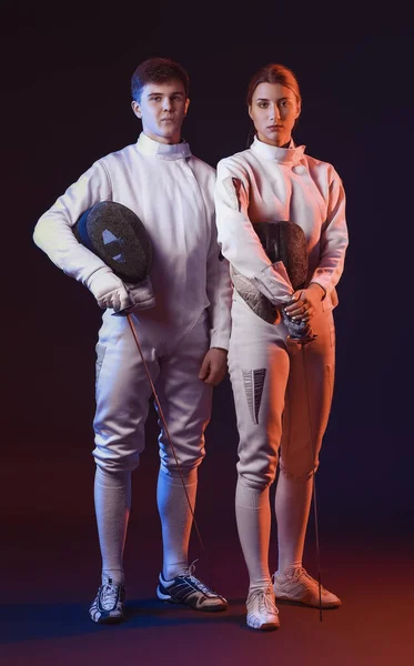 Toned photo of young fencers on dark background — Stock Photo, Image