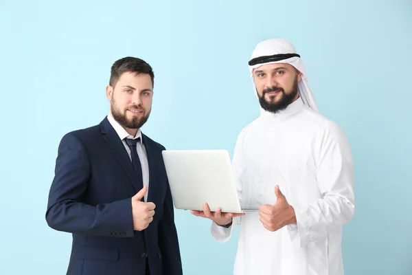 Άραβας και ο συνεργάτης του με φορητό υπολογιστή στο φόντο χρώμα — Φωτογραφία Αρχείου