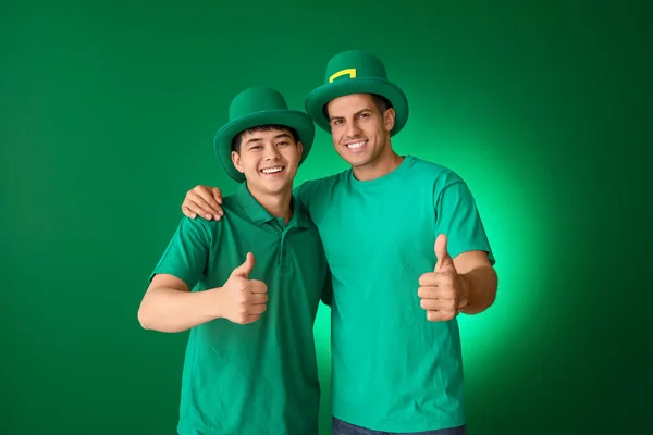 Young men showing thumb-up gesture on color background. St. Patrick's Day celebration — Stock Photo, Image