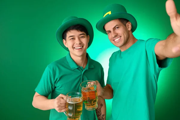 Jovens com cerveja tomando selfie no fundo de cor. Celebração do Dia de São Patrício — Fotografia de Stock