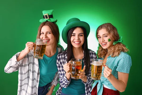 Jonge vrouwen met bier op gekleurde achtergrond. St. Patrick 's Day viering — Stockfoto