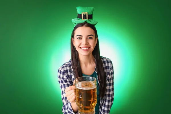 Jonge vrouw met bier op kleur achtergrond. St. Patrick 's Day viering — Stockfoto