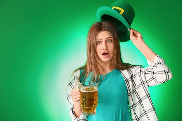Femme surprise avec de la bière sur fond de couleur. Célébration de la Saint Patrick — Photo