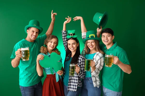 Vrienden met bier en klaver op kleur achtergrond. St. Patrick 's Day viering — Stockfoto