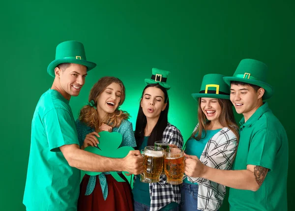 Vrienden met bier en klaver op kleur achtergrond. St. Patrick 's Day viering — Stockfoto