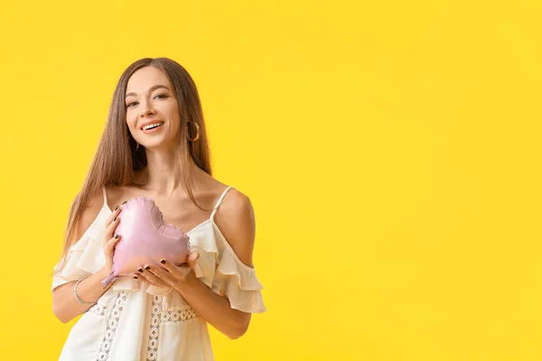 Hermosa joven con corazón sobre fondo de color. Celebración del Día Internacional de la Mujer — Foto de Stock