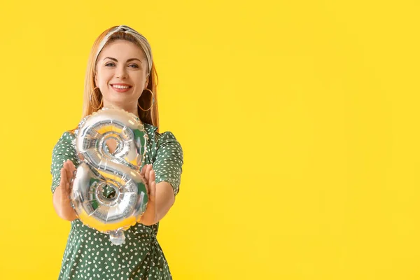 Beautiful young woman with balloon in shape of figure 8 on color background. International Women's Day celebration — Stock Photo, Image