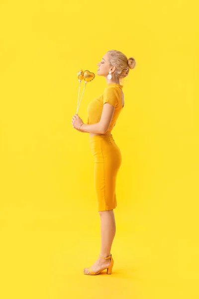 Beautiful young woman with party decor on color background. International Women's Day celebration — Stok fotoğraf