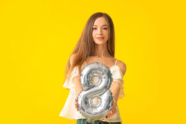 Beautiful young woman with balloon in shape of figure 8 on color background. International Women's Day celebration — Stock Photo, Image