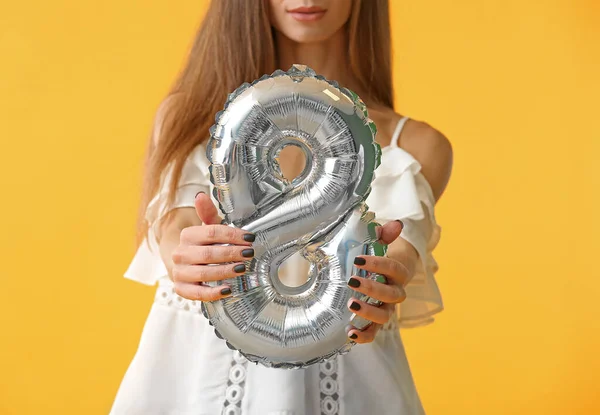 Gyönyörű fiatal nő léggömbbel alakja 8 alakja színes háttér. Nemzetközi nőnapi ünneplés — Stock Fotó