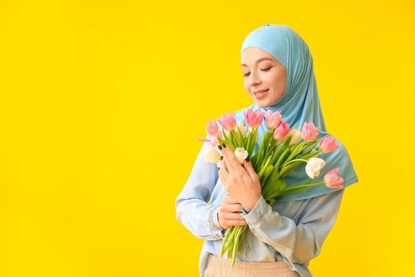 Krásná muslimská žena s květinami na barevném pozadí. Mezinárodní oslava Dne žen — Stock fotografie