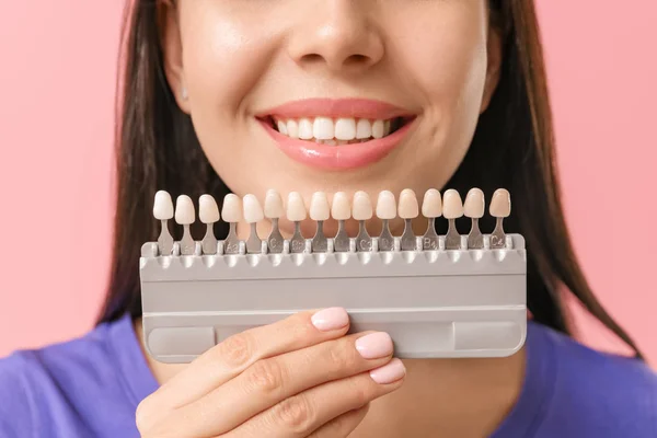 Mulher bonita com dentes amostras de cor no fundo de cor, close-up — Fotografia de Stock