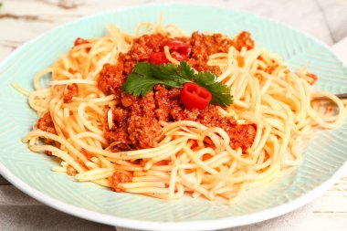 Plate with tasty pasta bolognese on table, closeup