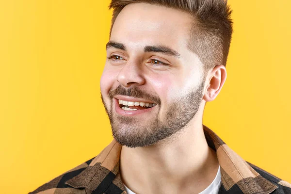 Handsome smiling young man on color background — Stock Photo, Image