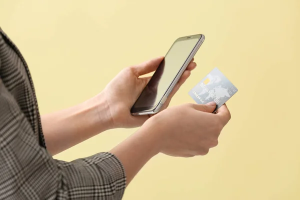 Woman with credit card and mobile phone on color background, closeup. Concept of online banking — 스톡 사진