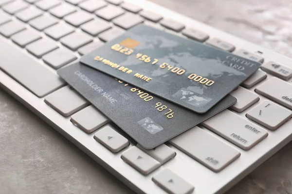 Credit cards with computer keyboard on grunge background, closeup. Concept of online banking — Stock Photo, Image