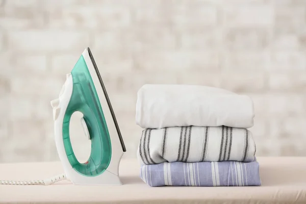 Modern iron and laundry on board in room — Stock Photo, Image