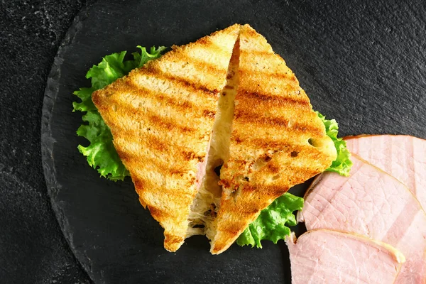 Tasty sandwiches with cheese and ham on dark background — Stock Photo, Image