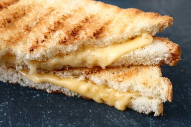 Tasty sandwiches with cheese on table, closeup