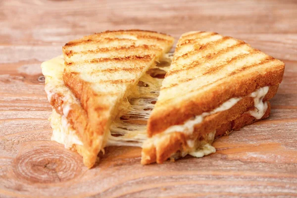 Sanduíches saborosos com queijo no fundo de madeira — Fotografia de Stock