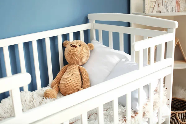 Niedlicher Spielzeugbär im Babybett — Stockfoto