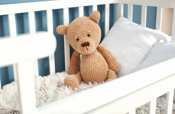 Cute toy bear in baby crib — Stok fotoğraf