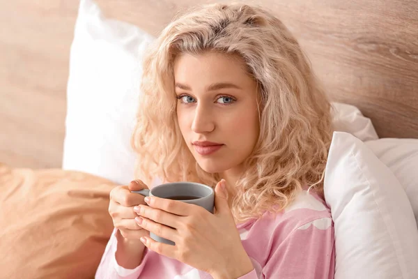 Morning of beautiful young woman drinking coffee in bed — Stock Photo, Image