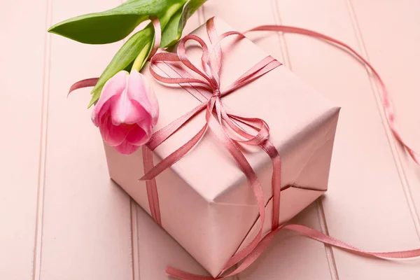 Packed gift and flower on wooden background — Stock Photo, Image