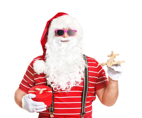 Santa Claus s dárkem a hračka letadlo na bílém pozadí. Koncept dovolené — Stock fotografie