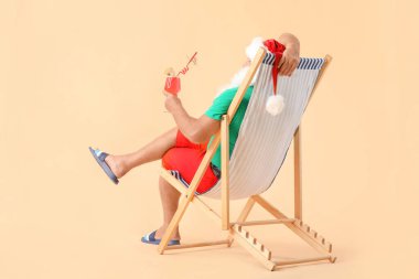 Noel Baba, arka planda güneşlenerek oturuyor. Tatil kavramı