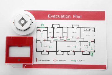 Evacuation plan, smoke detector and manual call point on white background