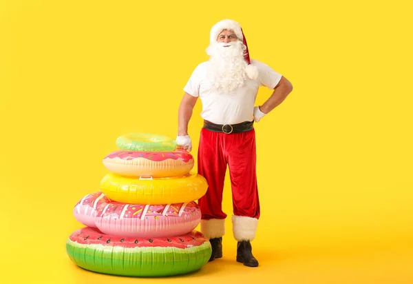 Santa Claus with swimming rings on color background. Concept of vacation — Stock Photo, Image