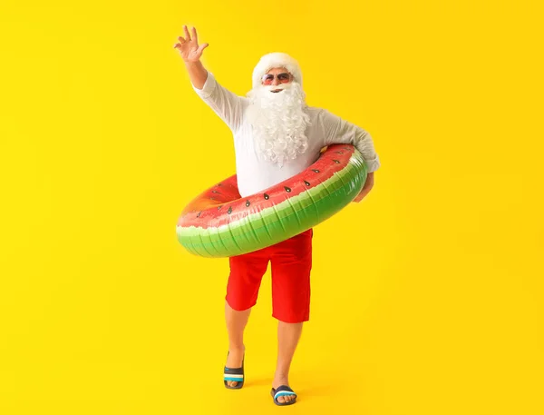 Babbo Natale con anello di nuoto su sfondo a colori. Concetto di vacanza — Foto Stock