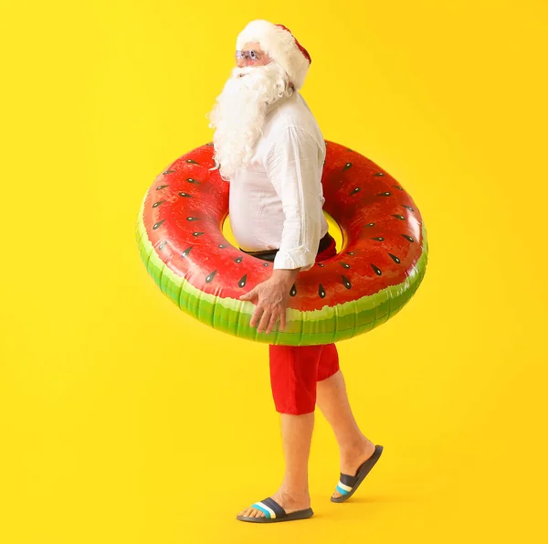 Santa Claus with swimming ring on color background. Concept of vacation — Stock Photo, Image
