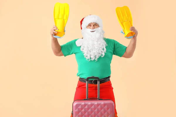Санта Клаус з багажем і веслами на кольоровому тлі. Концепція відпустки — стокове фото