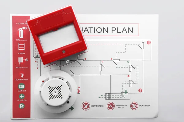План эвакуации, детектор дыма и ручной вызов на белом фоне — стоковое фото