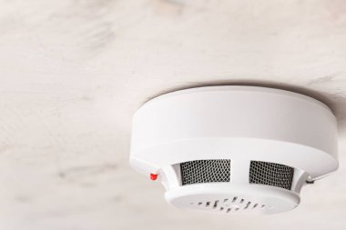 Modern smoke detector on ceiling