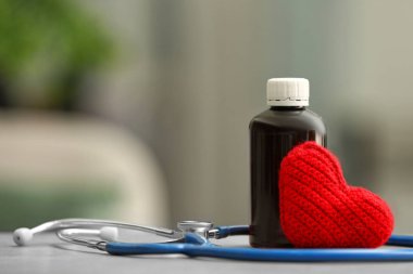 Stethoscope, remedy and heart on table