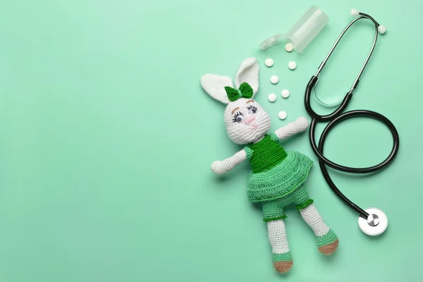 Estetoscopio, pastillas y juguetes para bebés sobre fondo de color — Foto de Stock