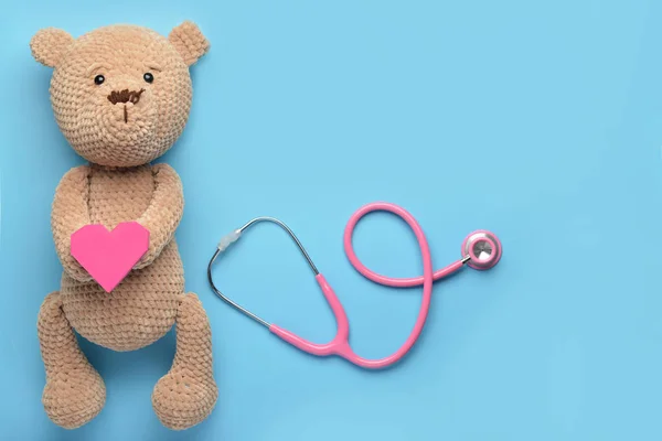 Stethoscope, baby toy and heart on color background — Stok fotoğraf
